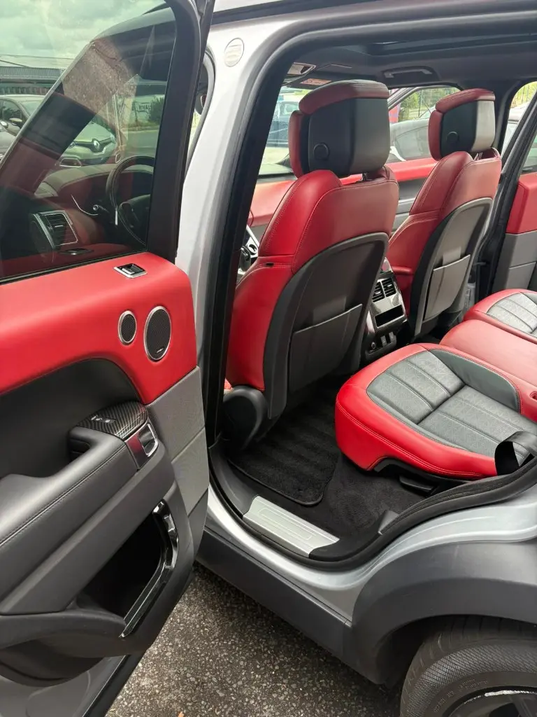 Habitacle arrière d'un Range Rover Sport, sièges cuir rouge et noir après nettoyage complet