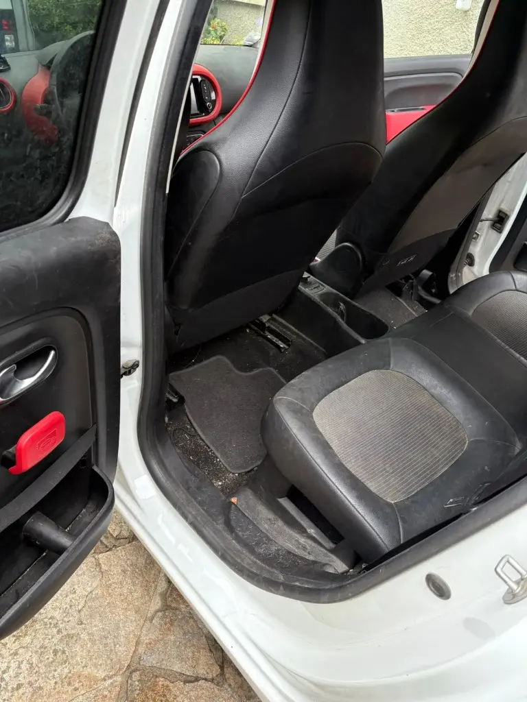 Habitacle arrière droit Renault Twingo avant nettoyage : résidus au sol et seuil marqué